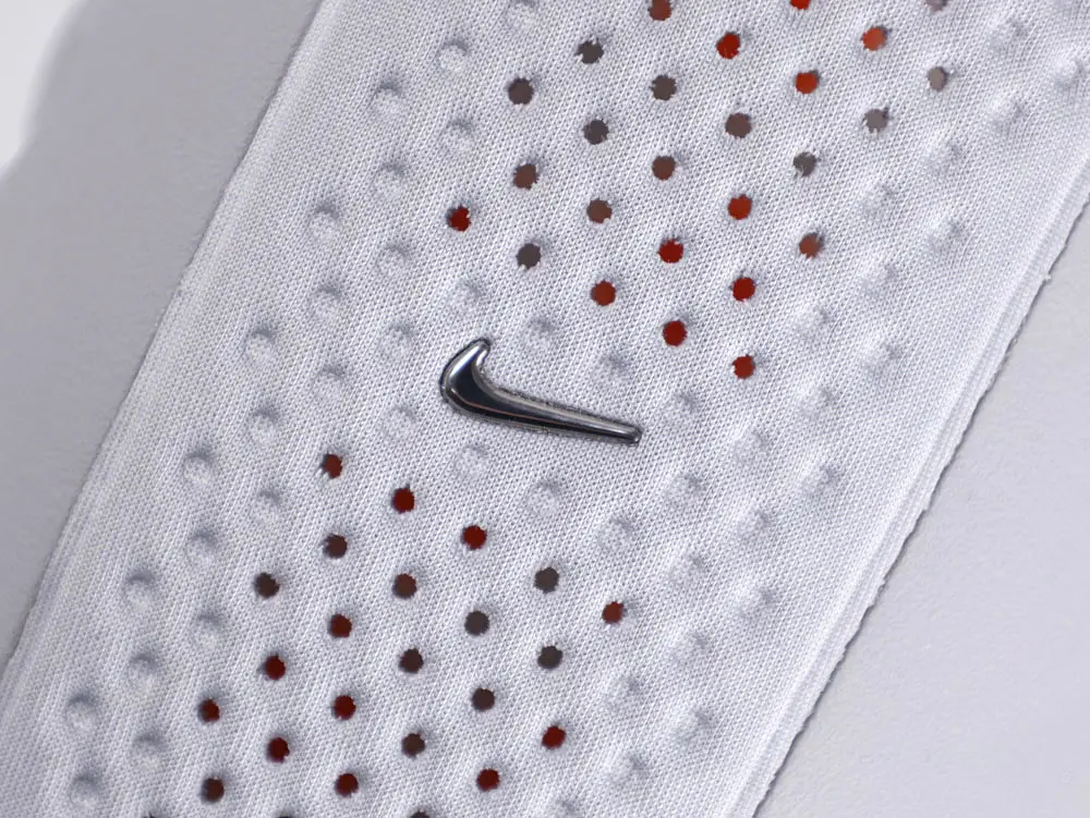 White rubber shoe sole with embossed text design and bright orange circular elements.