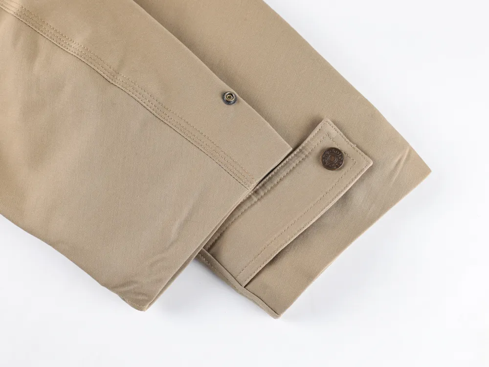 Sleeve with metal button, highlighting stitching and folded design.
