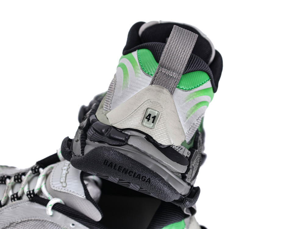 Gray and green sneaker with textured fabric, showing back heel part.