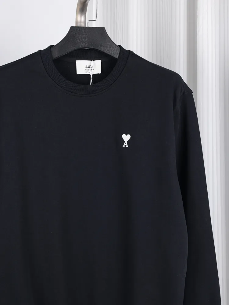 Sweatshirt with round neckline and small white heart emblem.
