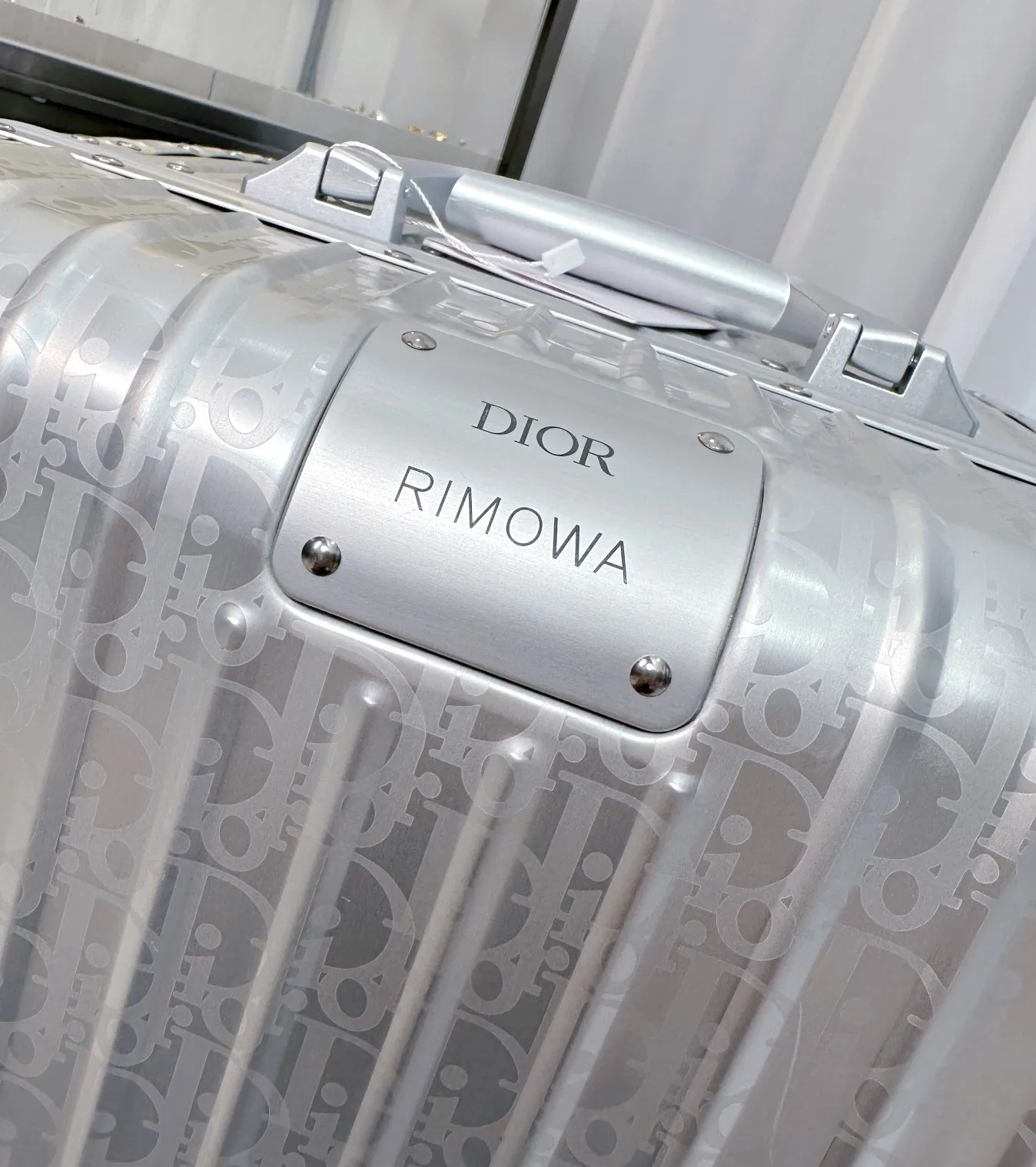 Close-up of Dior Rimowa logo plate