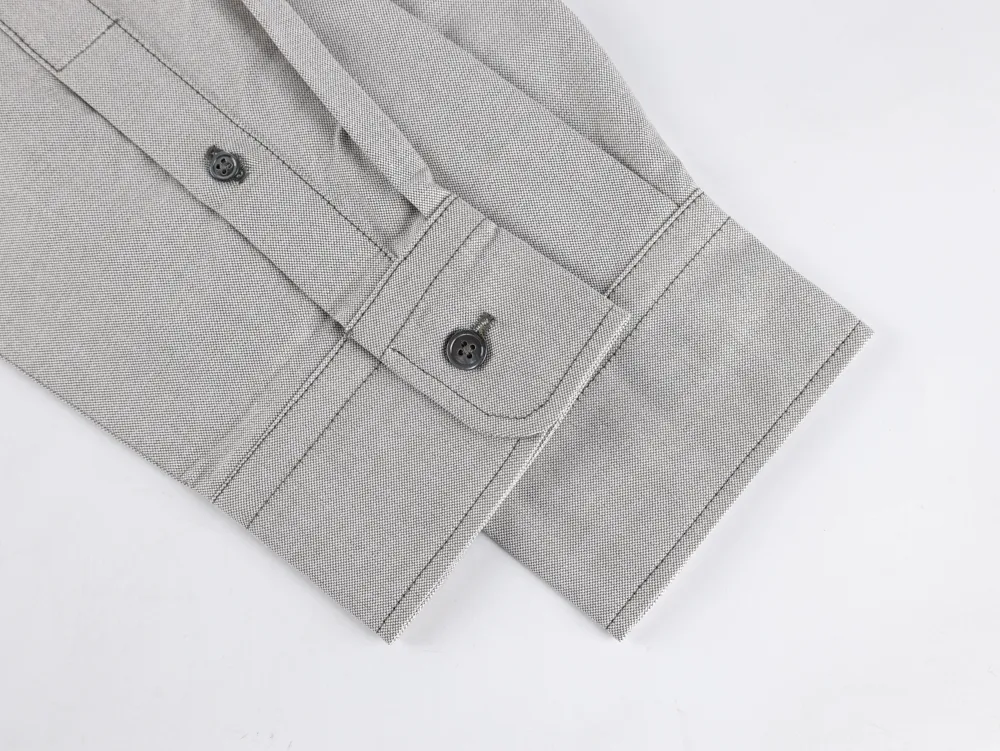 Cuff with buttons, showcasing textured material and precise stitching.