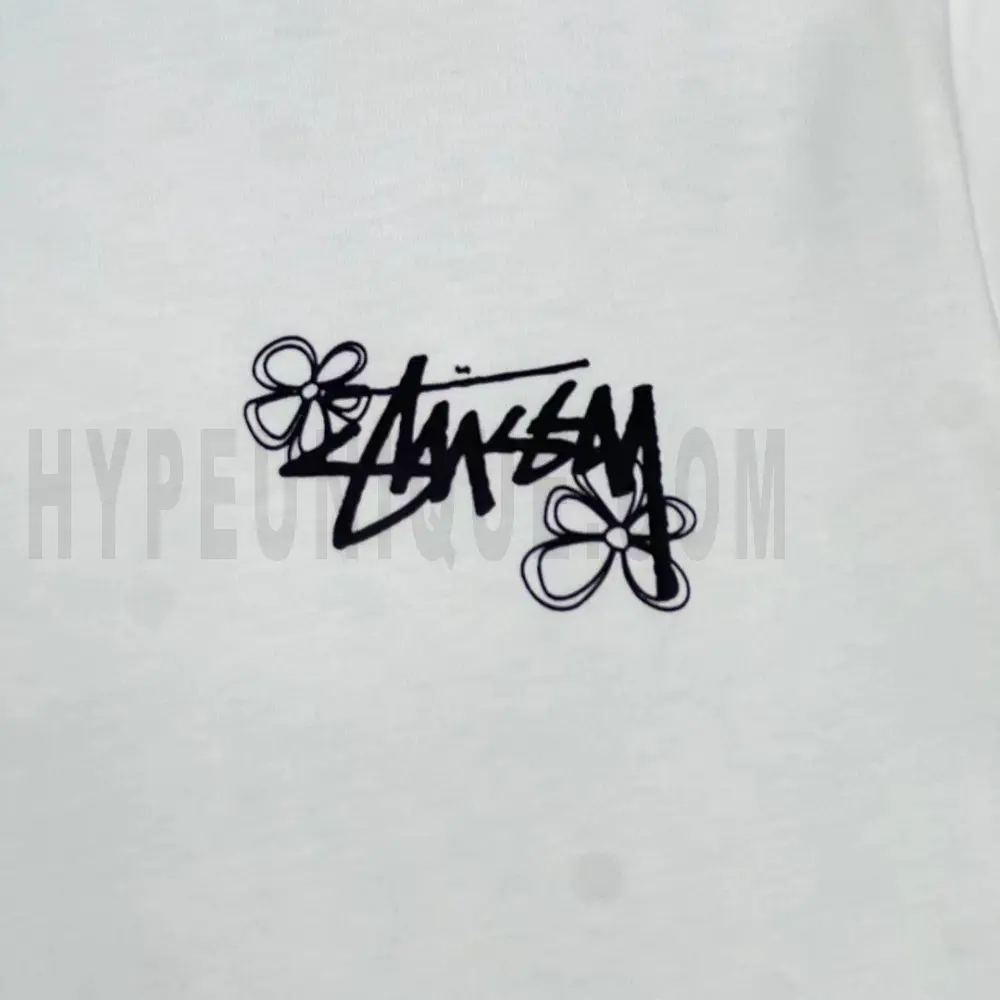 Detailed shot capturing the graphic print on the white tee's front panel.