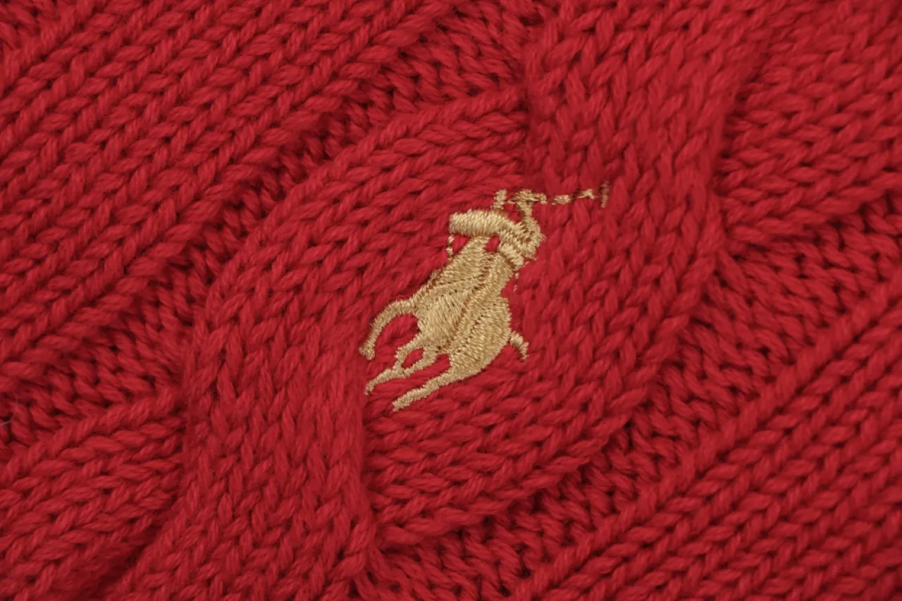 Gold embroidered logo detail.