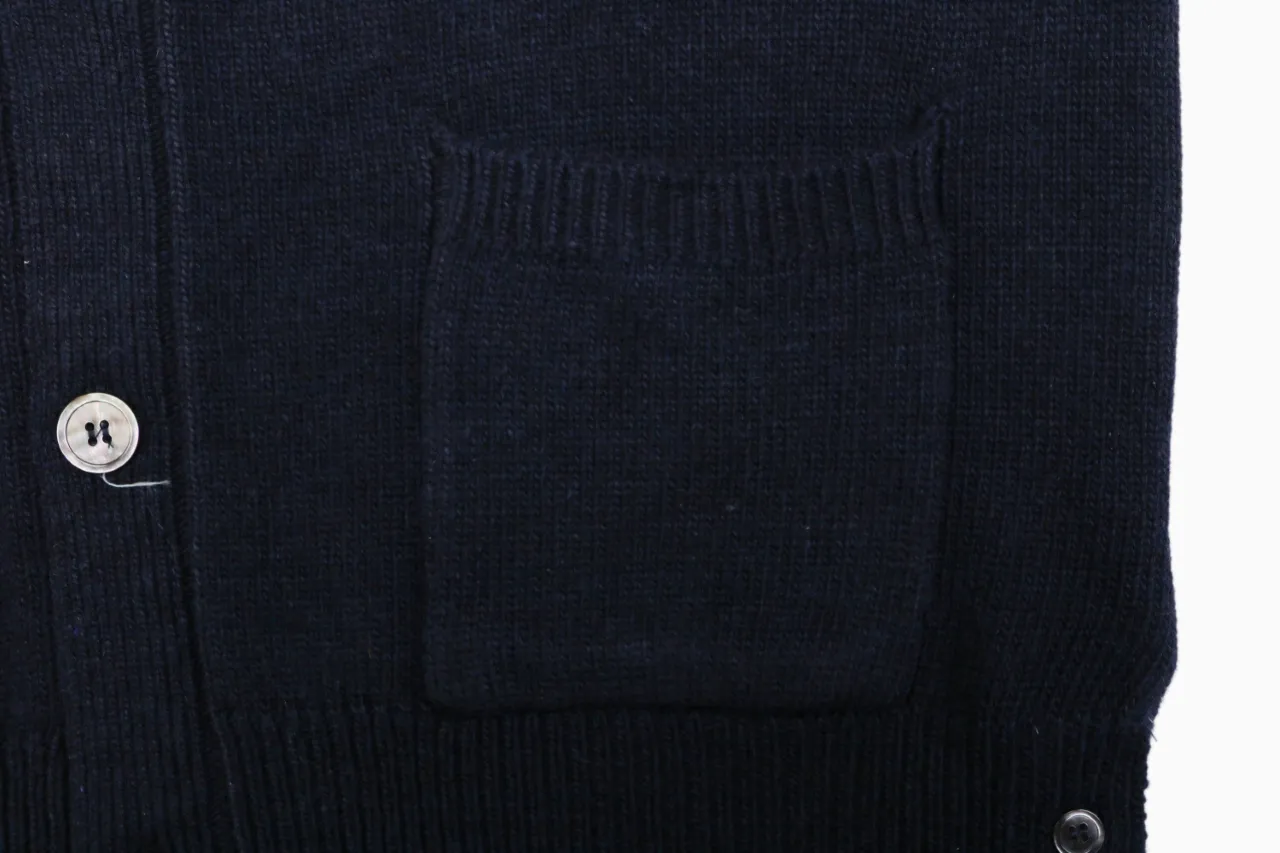 Front pocket detail on navy knit cardigan.