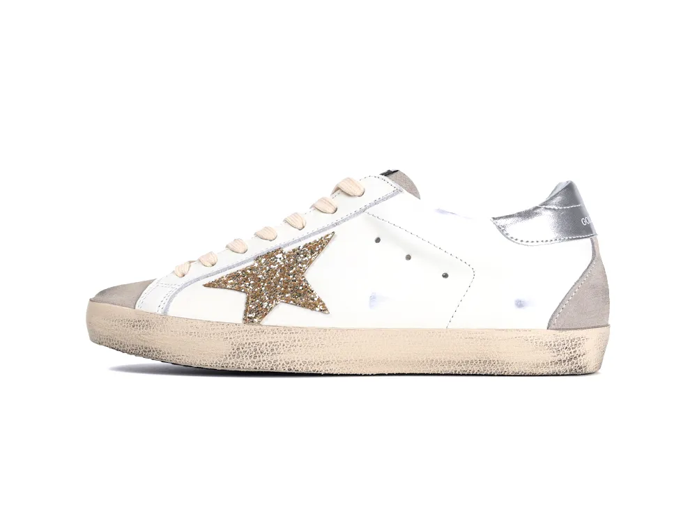 Side view of white Golden Goose sneakers with gold glitter star