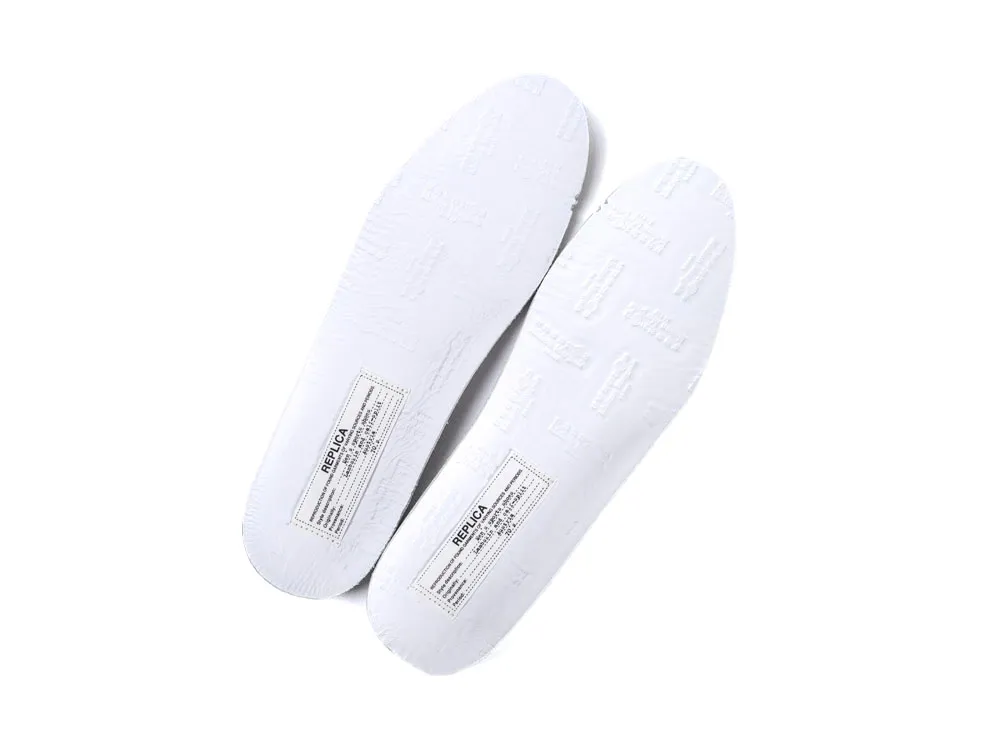 White rubber shoe soles with embossed texture and label details.