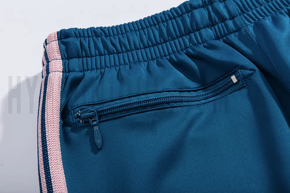 Detail of the back zip pocket on the track pants.