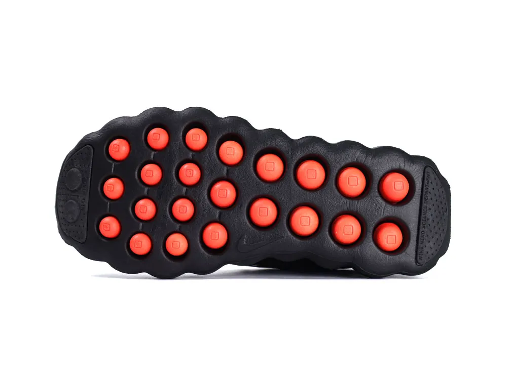 Black rubber shoe sole with red circular grips.