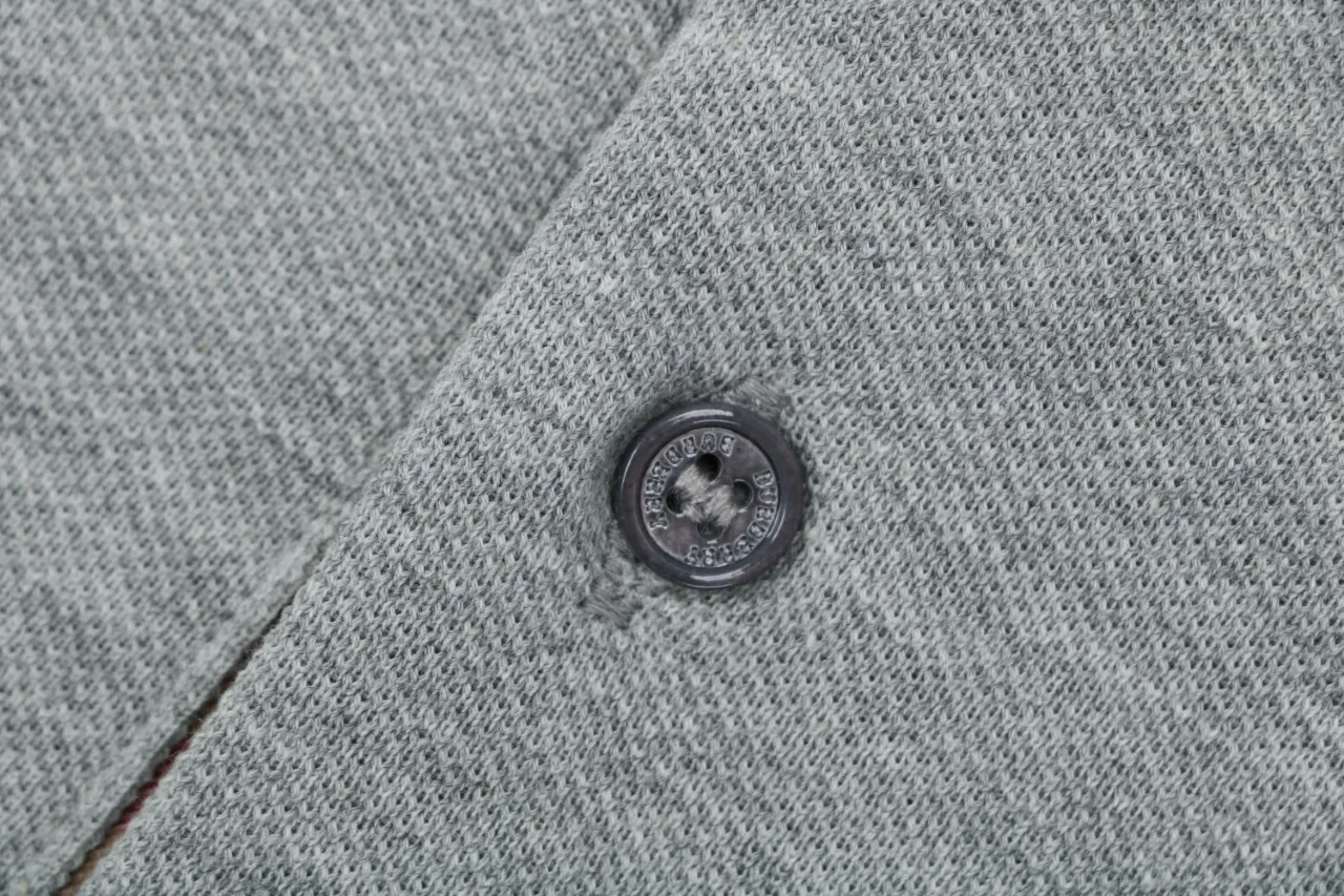 Black button detail, showing soft knitted texture.