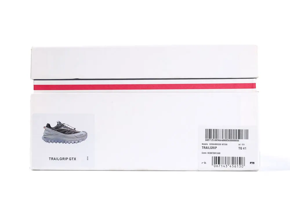 White shoe box with a red stripe; features a sneaker image on the side. Labels and barcodes are visible.