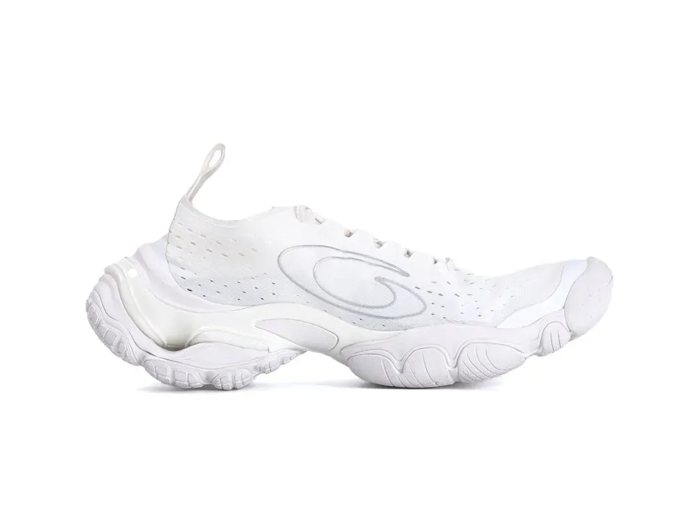 White mesh sneaker with a curvy design and thick, textured rubber sole.