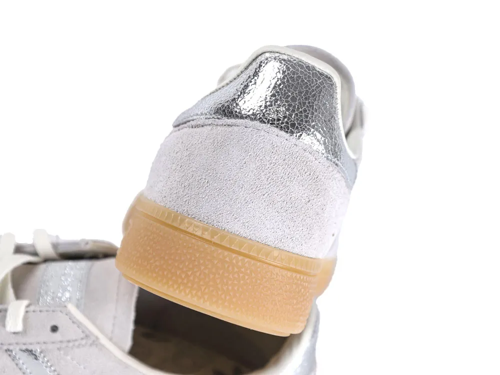 Silver and white suede sneaker heel with gum rubber sole accent.