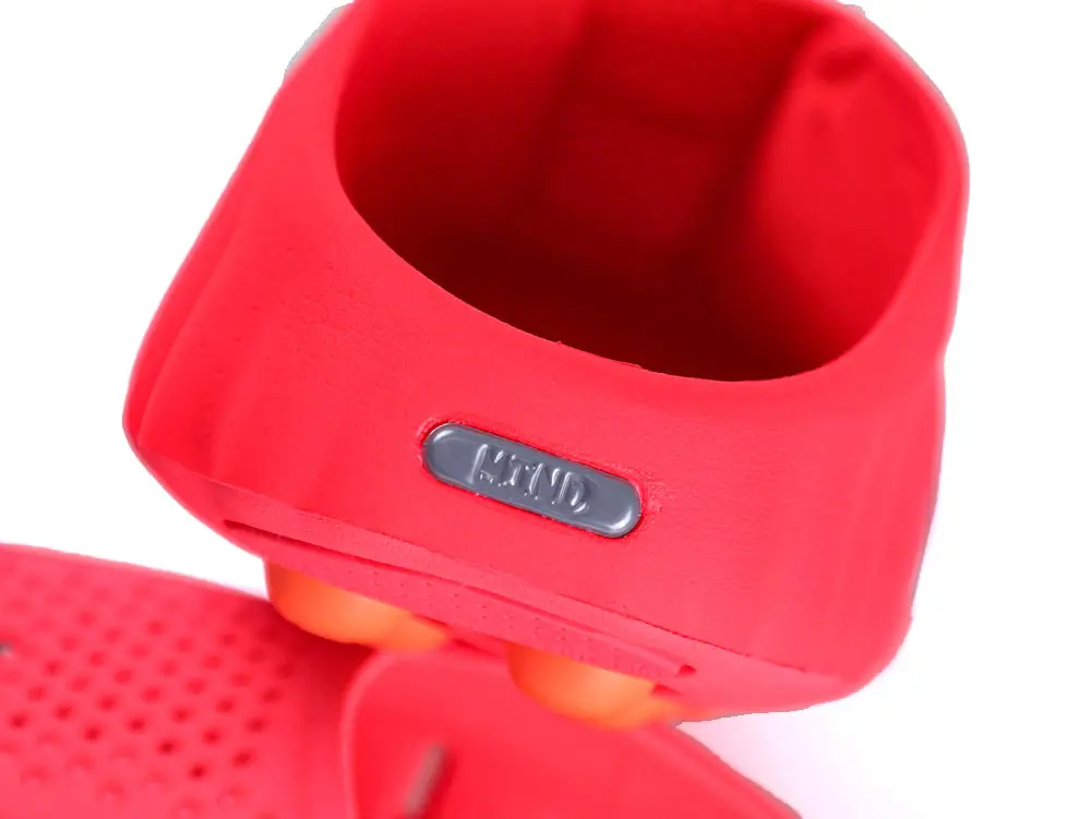 Red silicone shoe with a gray logo plate and orange components.