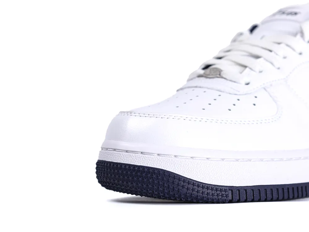 Close-up of white leather sneaker with dark rubber sole, showcasing the toe area.
