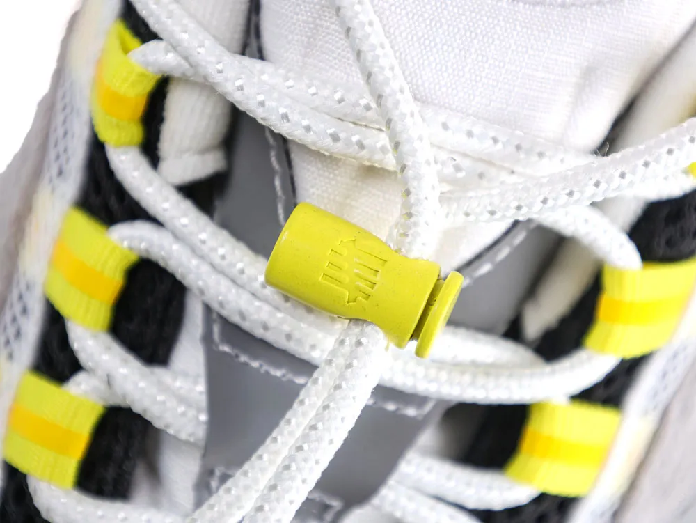 Close-up of sneaker laces with yellow plastic lace lock detail.