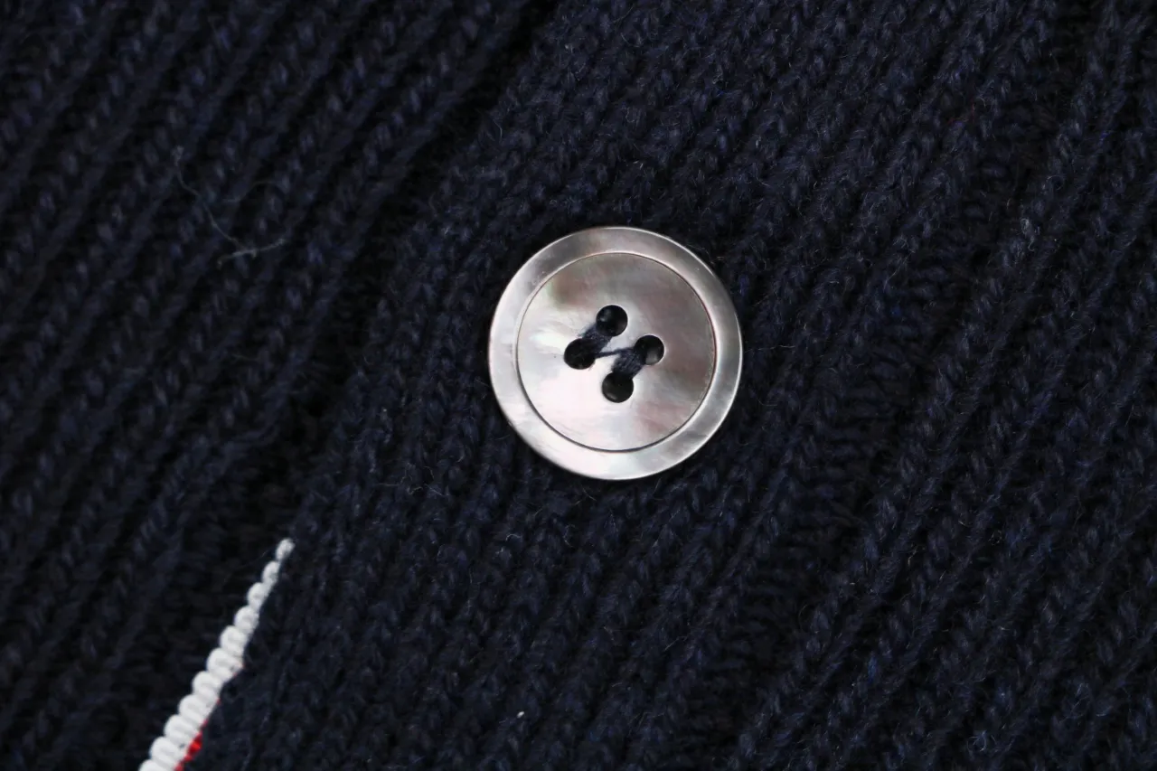 Close-up of button detail on navy knit cardigan.