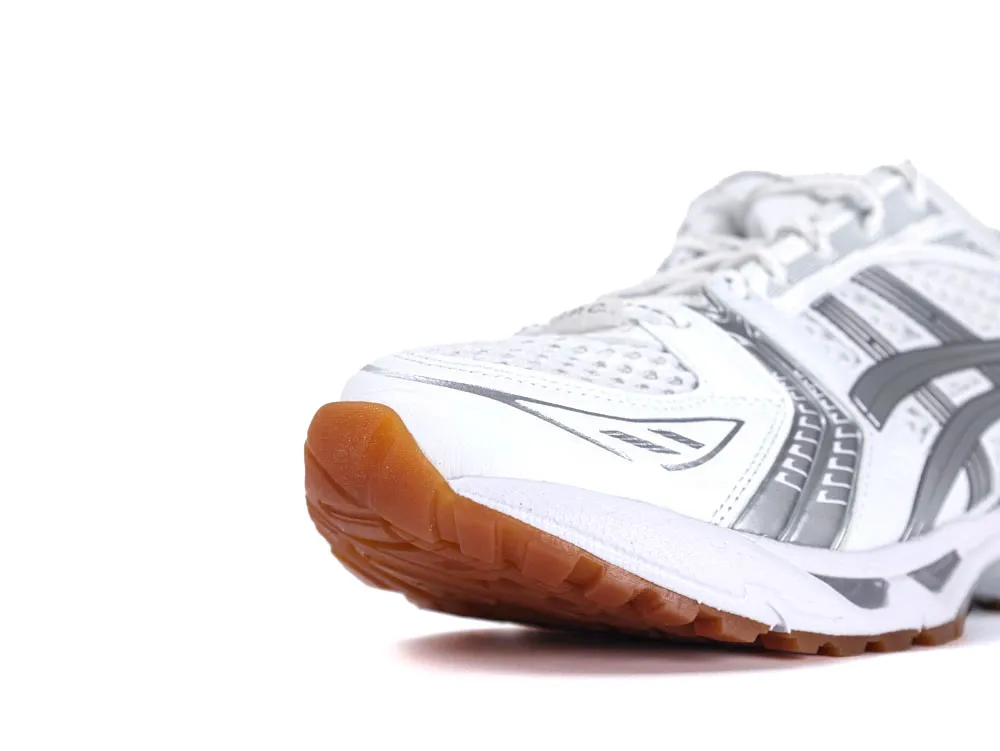 White and gray sneaker with mesh material and brown rubber sole detail.