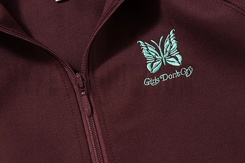 Close-up of butterfly embroidery detail on the chest of the jacket.