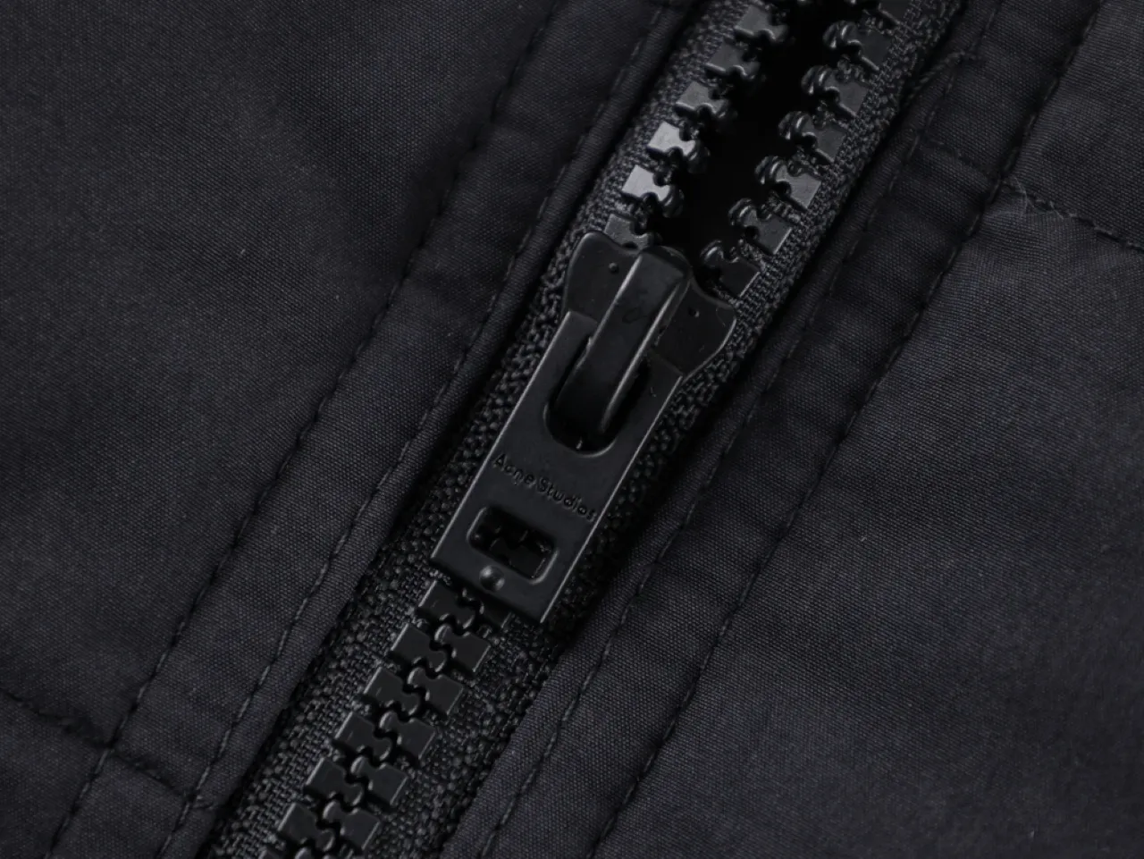 Zipper on dark fabric material.