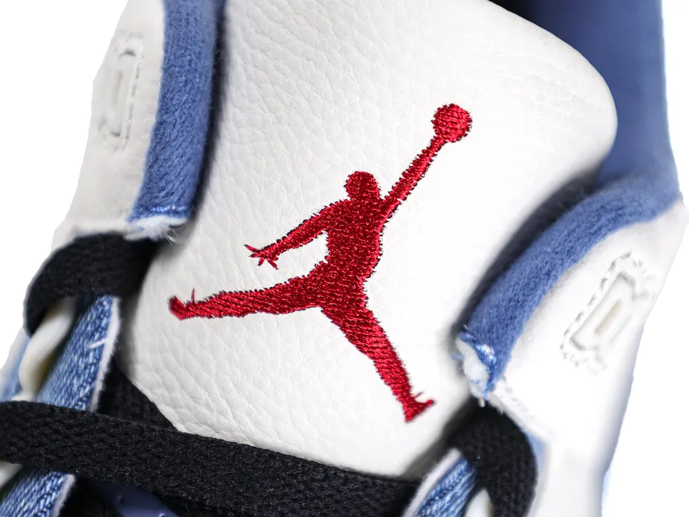 Close-up of the sneaker tongue featuring a red embroidered Jumpman logo on white tumbled leather, bordered by blue denim material.