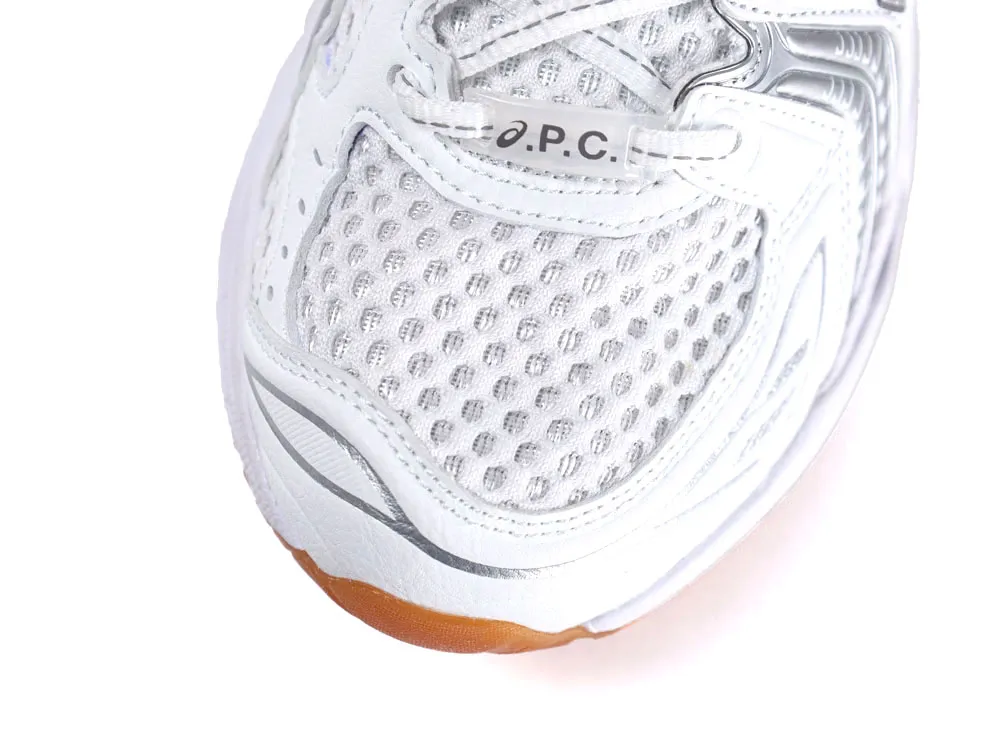 Close-up of white mesh sneaker with synthetic leather accents and gum sole tip.