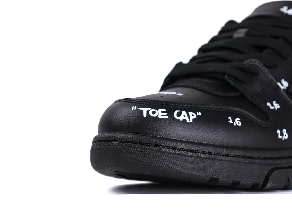 Black leather shoe with "TOE CAP" text, featuring a detailed toe design.