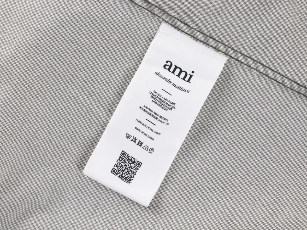 White label, likely cotton material, showing care instructions.