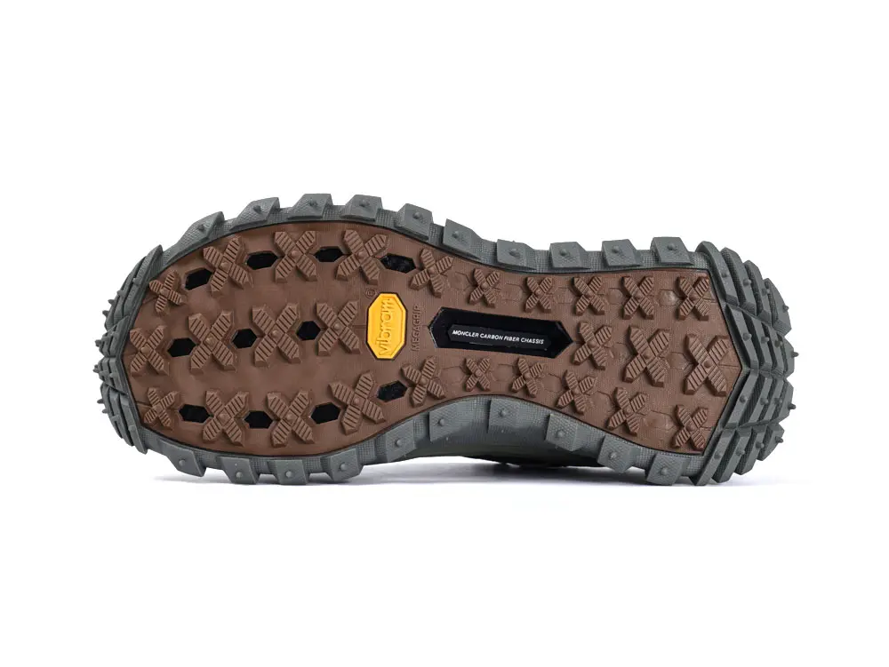 The image shows a brown sneaker sole with intricate patterns and grey edges, highlighting tread details and texture.