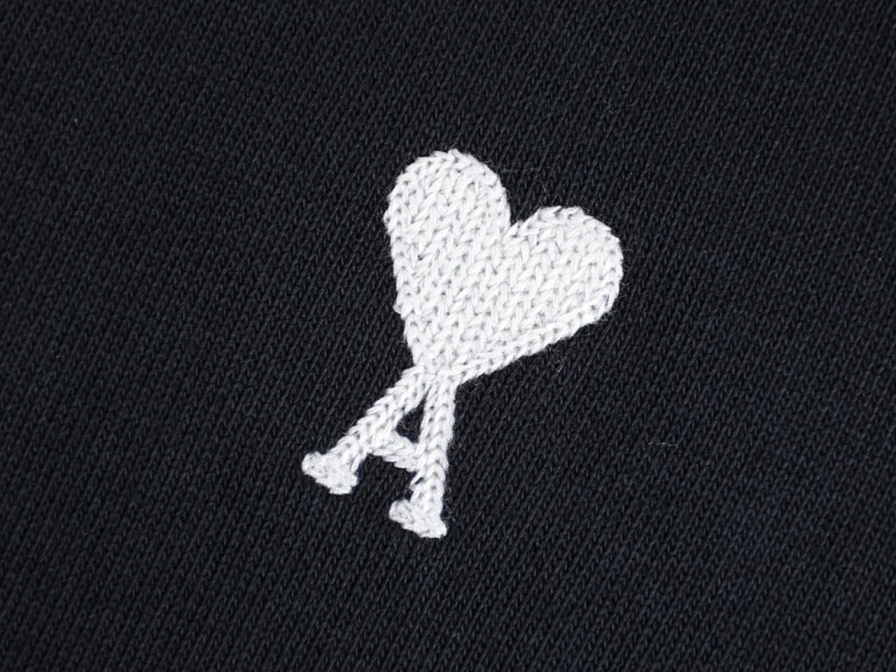 White embroidered heart motif on black fabric
