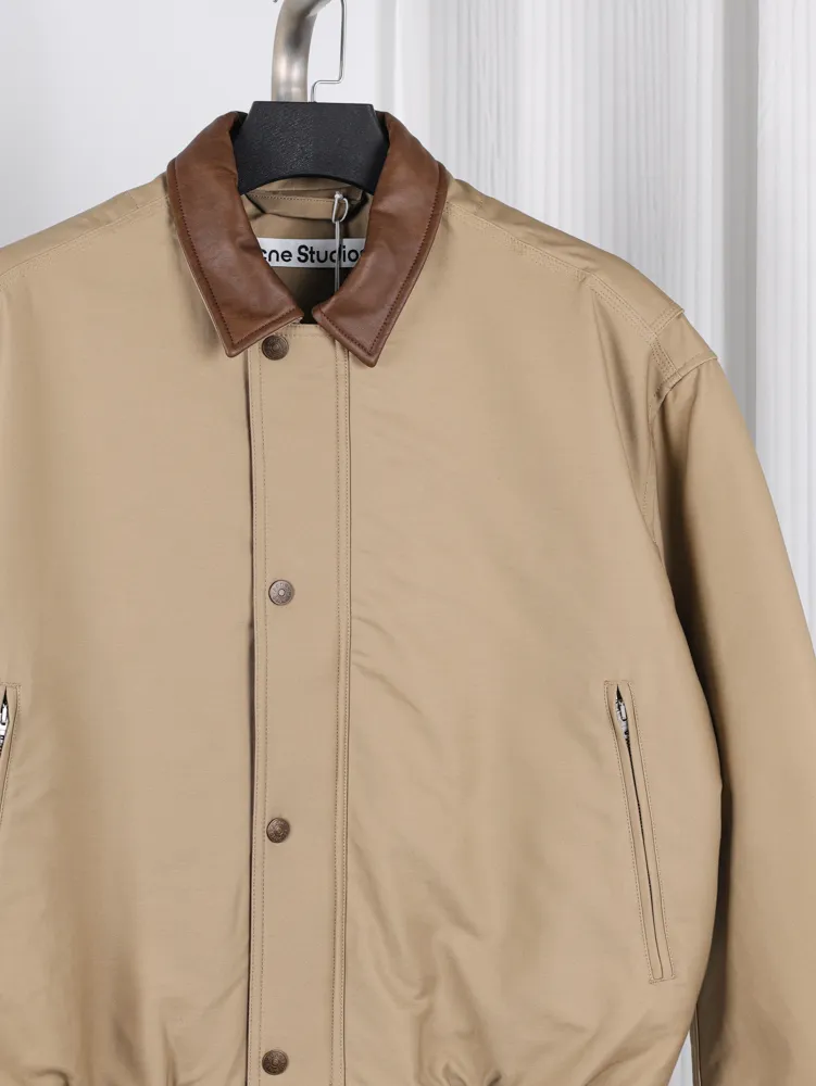 Tan jacket with a brown leather collar, buttoned front, and side pockets.