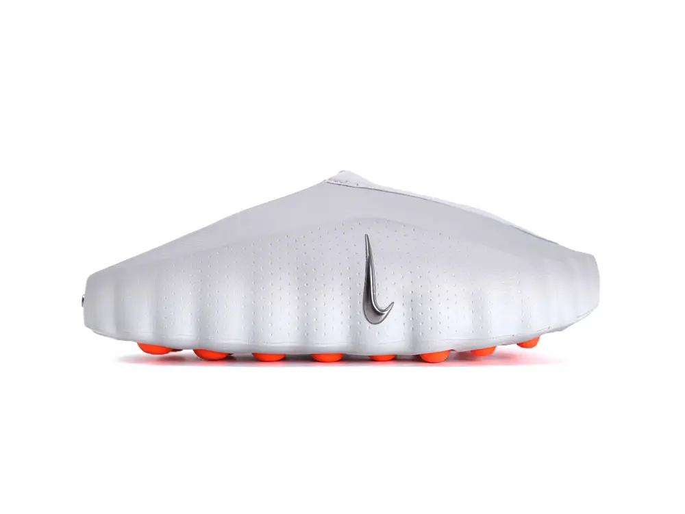 White synthetic shoe with silver logo and bright orange studs on the sole.
