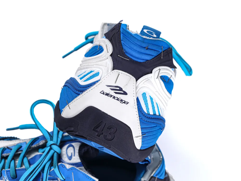 Close-up of a blue, white, and black sneaker heel with logo and thick laces.
