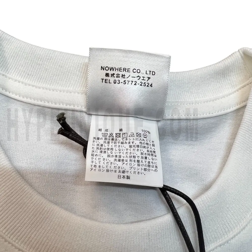 Neckline tag close-up, displaying garment care symbols and brand information with fashion-forward presentation.
