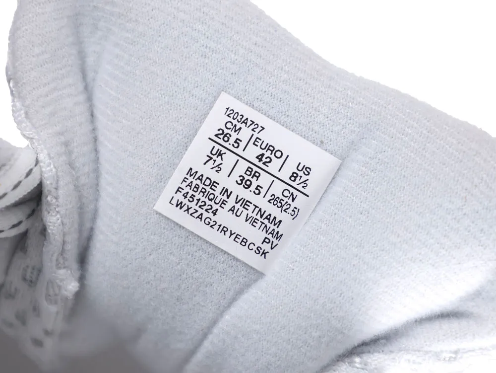 White fabric sneaker tongue with a printed size label, showing detailed measurements.