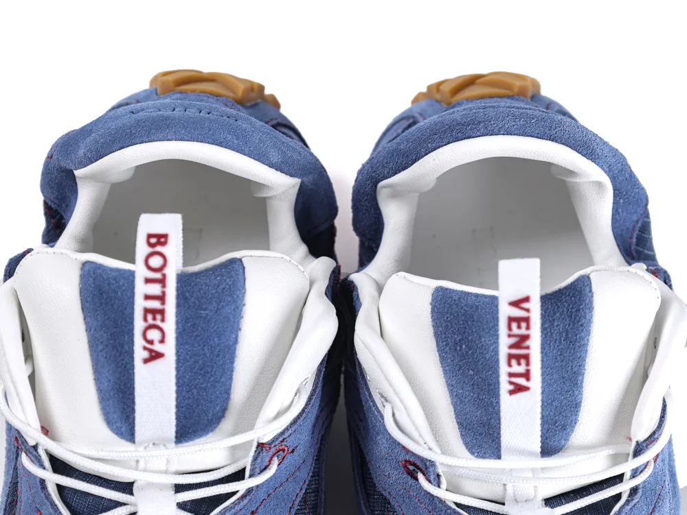 Blue suede sneakers with white interior and brown accents, featuring branded heel tabs.