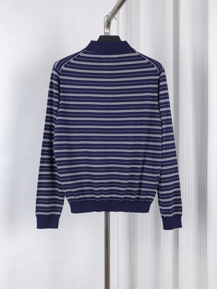 Navy blue striped knit sweater with white lines, featuring long sleeves and ribbed cuffs.