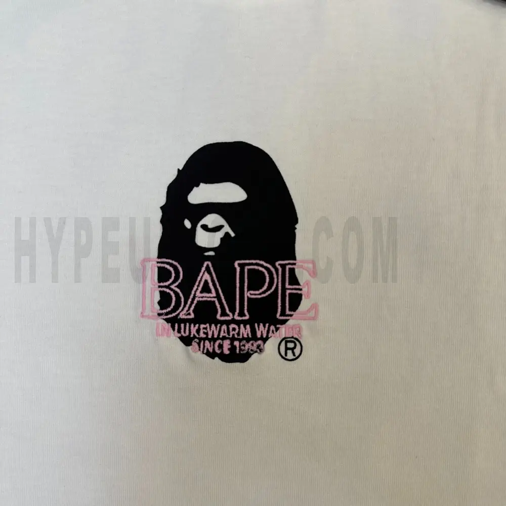 Detailed shot capturing the graphic print on the white tee's front panel.