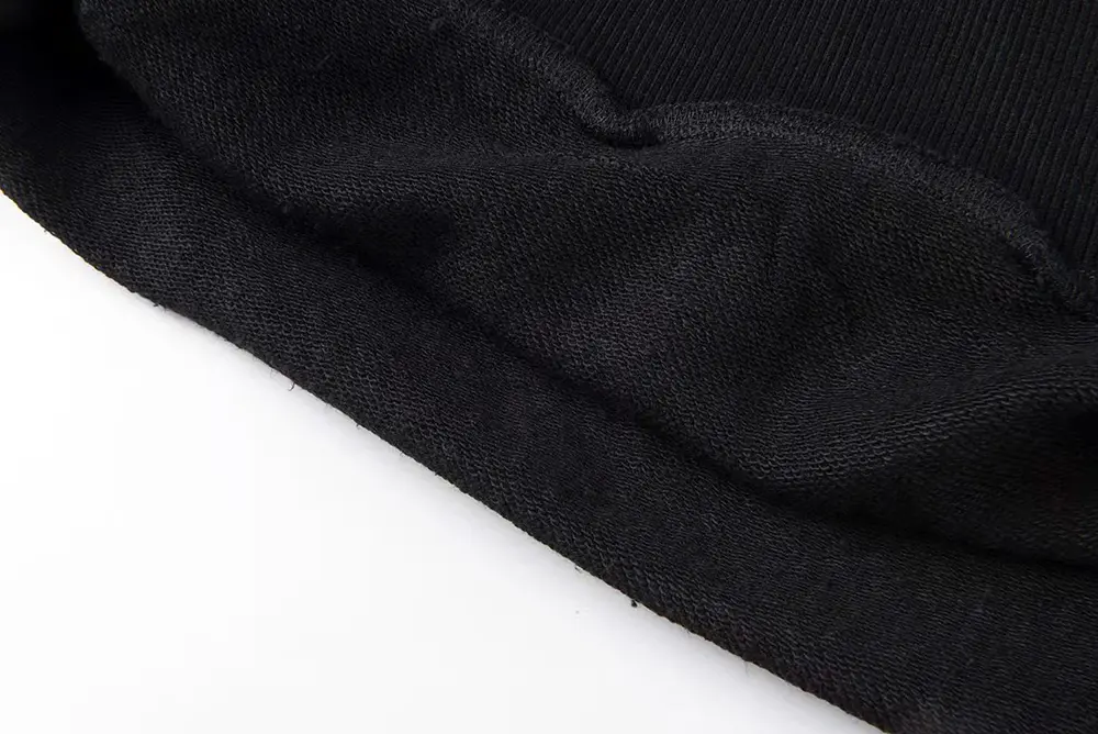 A top-down view of the hem of the Sp5der VVS Hoodie in Black, highlighting its cotton and polyester material and the full rhinestone detailing
