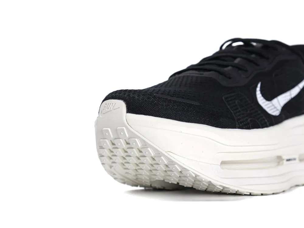 Black and white sneaker with a mesh upper and rubber sole, close-up view.