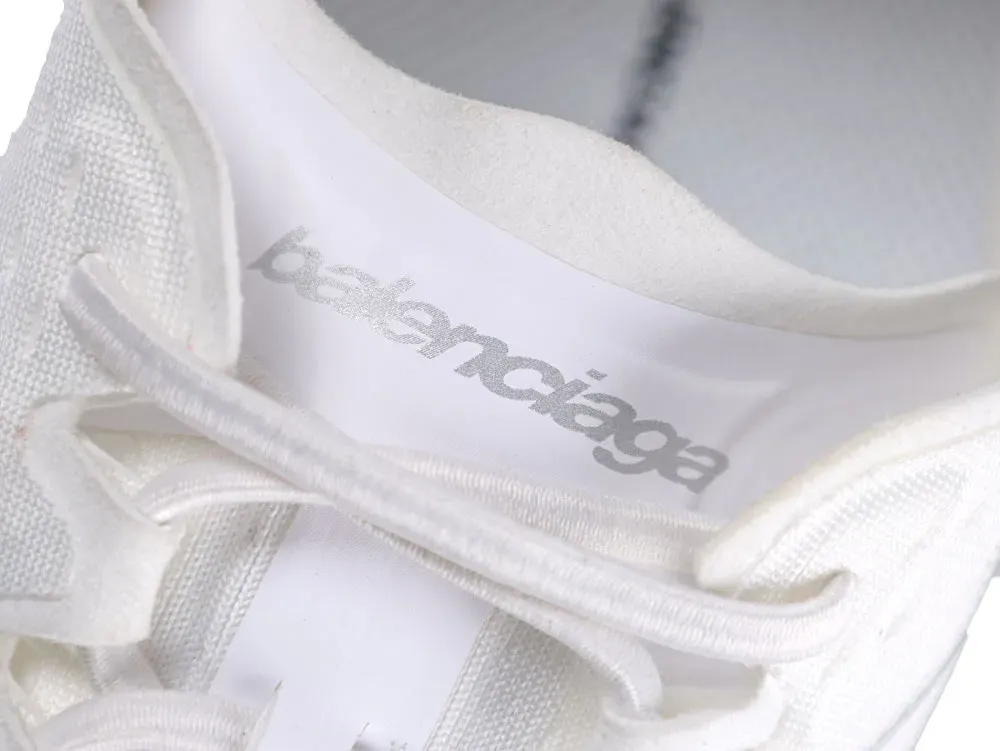 White fabric sneaker with laces, featuring visible brand name on insole.