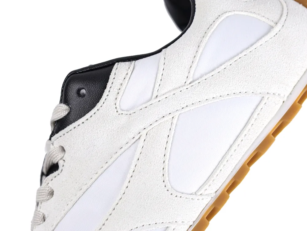 White and black shoe with suede and mesh upper, gum sole detail.