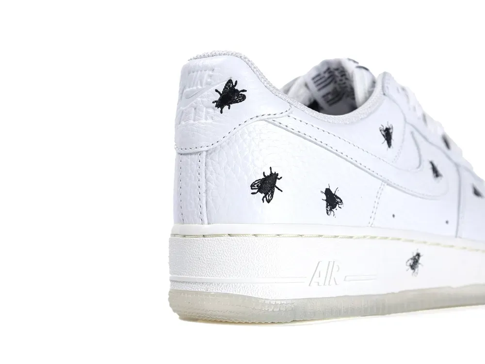 White leather sneakers with black embroidered insect designs on the heel and sides.