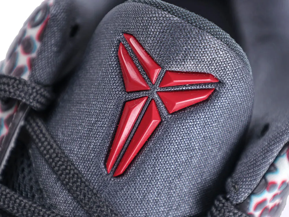 Gray fabric shoe tongue with a red plastic emblem and black laces.