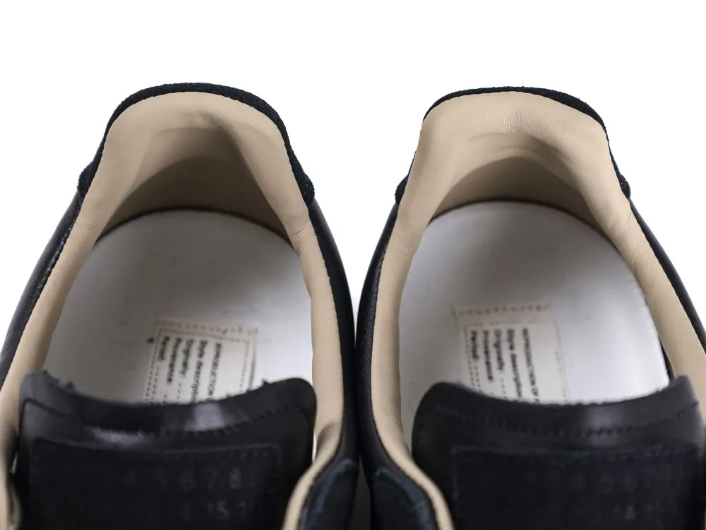 Black leather shoes with beige interior lining, close-up view of the heel area.