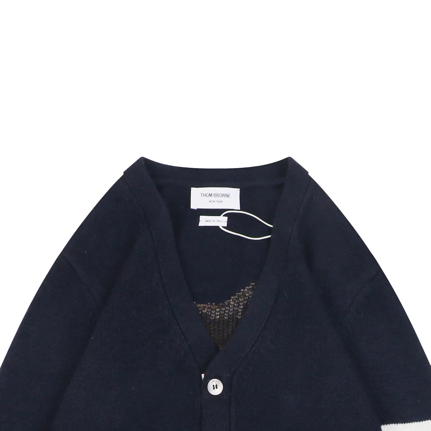 Close-up of navy knit cardigan neckline and brand label detail.