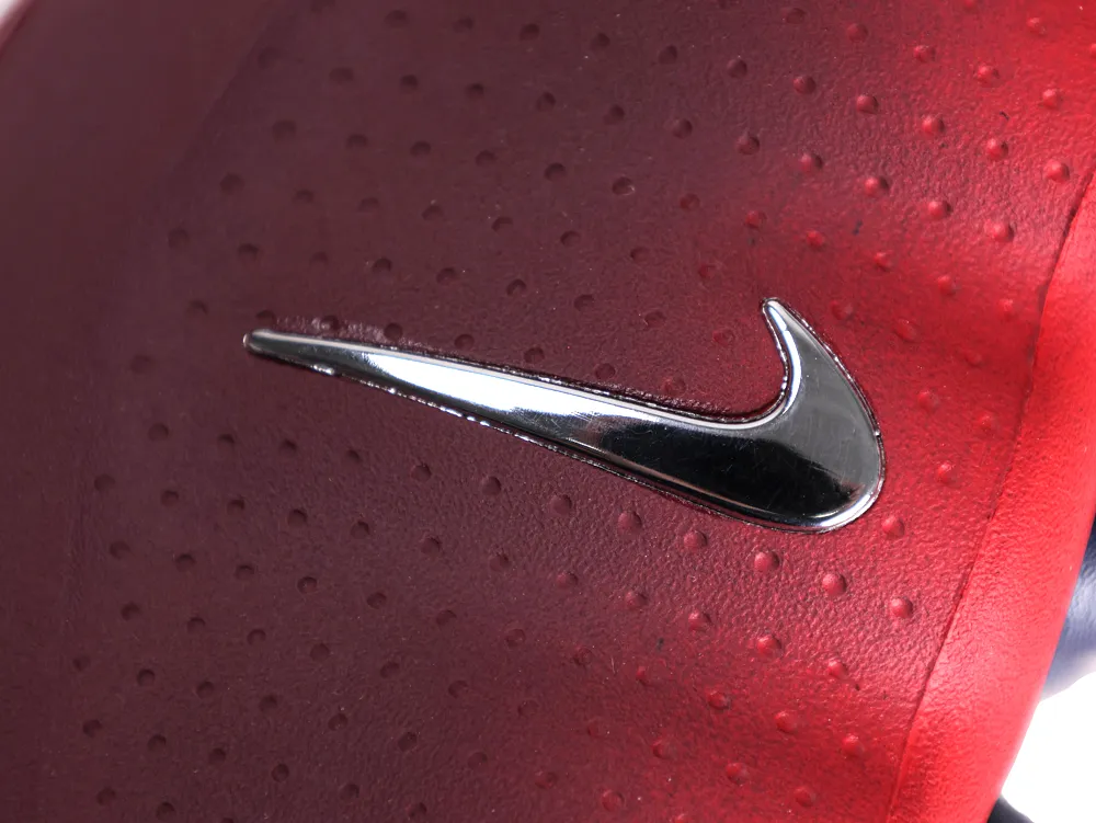 Detailed view of the metallic silver Nike swoosh on the textured side panel of the shoe.