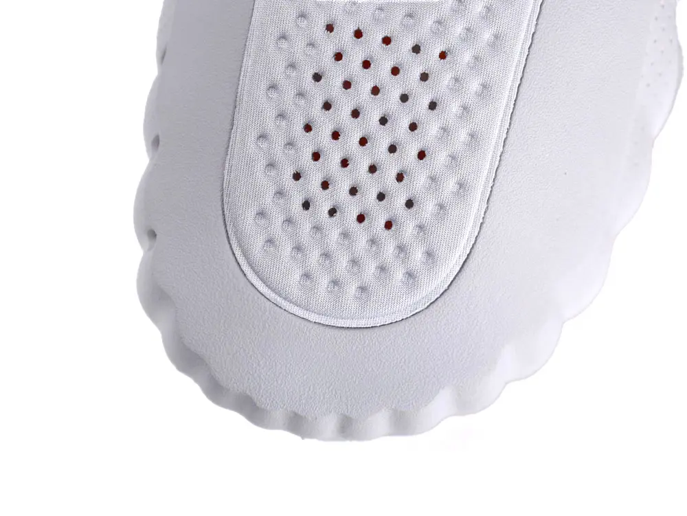 White shoe toe made of textured fabric and smooth material with perforations.