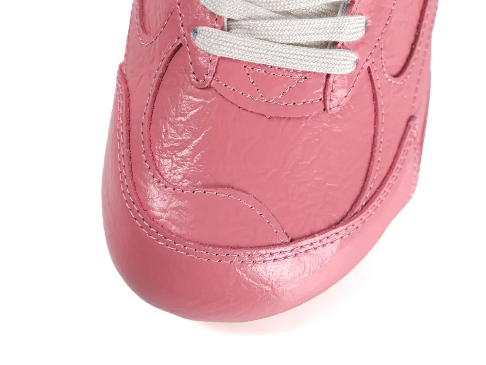 Overhead view of the pink leather toe box featuring tonal stitching and white cotton laces.