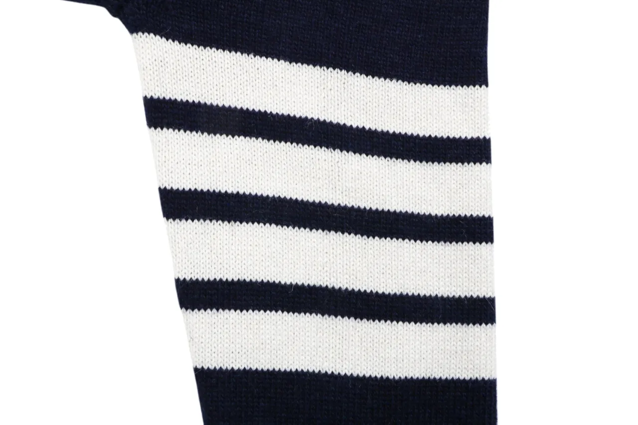 Four-bar stripe detail on navy knit cardigan sleeve.